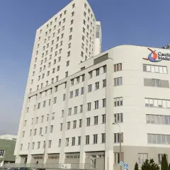 Nowoczesny budynek Carolina Medical Center w Warszawie z napisem "Ostry Dyżur Ortopedyczny".