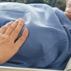 Dłoń na piersi pacjenta z tachypnoe, wsparcie w trudnych chwilach.