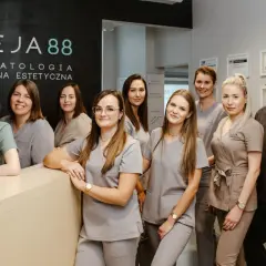 Zespół uśmiechniętych dentystów i personelu medycznego w gabinecie stomatologicznym.