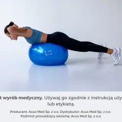 Kobieta ćwiczy na niebieskiej piłce rehabilitacyjnej, leżąc na brzuchu.