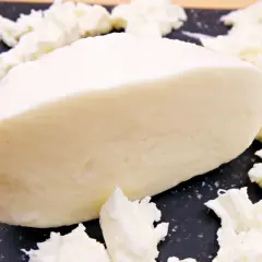Kawałek świeżej mozzarelli otoczony postrzępionymi kawałkami sera. Idealny do sałatek, a jego mozzarella kcal sprawia, że jest to zdrowy wybór.