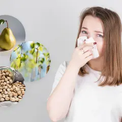 Alergia? Gruszka, pyłki brzozy i ciecierzyca mogą wywoływać objawy. Kobieta z chusteczką przy nosie.