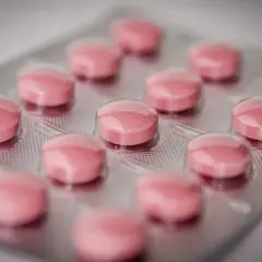 Blister opakowanie różowych tabletek, być może amoksycylina, gotowe do leczenia.