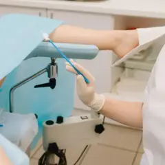 Lekarz przygotowuje się do ginekologicznego badania cytologicznego, pobierając wymaz do analizy.