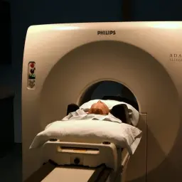 Pacjent leży na łóżku aparatu do tomografii głowy Philips ADAC Allegro.