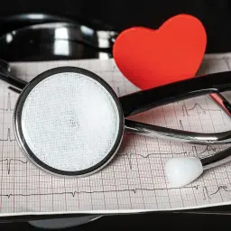 Stetoskop i czerwone serce na tle zapisu EKG. Dbamy o Twoje nt probnp.