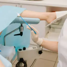 Lekarz przygotowuje się do ginekologicznego badania cytologicznego, pobierając wymaz do analizy.