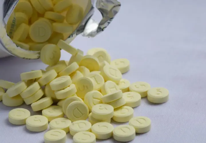 Żółte tabletki, niektóre z literą "D", rozsypane z opakowania. Może to być relanium.