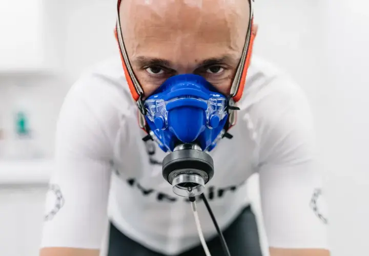 Mężczyzna w masce do testów wysiłkowych, badający swoje VO2max.