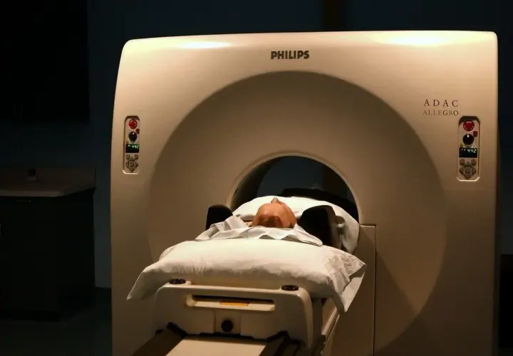 Pacjent leży na łóżku aparatu do tomografii głowy Philips ADAC Allegro.