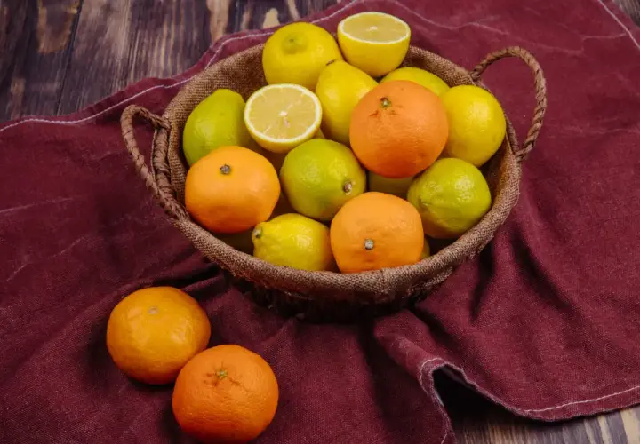 Koszyk pełen cytrusów: pomarańczy, cytryn i limonek. Te owoce są bogate w hesperydynę, cenny flawonoid.