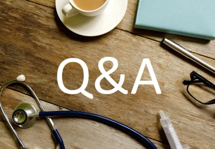 Stetoskop, kawa i notatnik na drewnianym stole. Sesja Q&A, być może dotycząca genetyki, np. HLA B27.