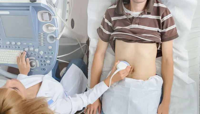 Lekarz wykonuje USG jamy brzusznej, aby przeprowadzić test na zapalenie wyrostka robaczkowego.
