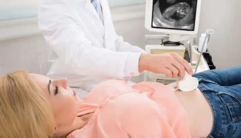Lekarz wykonuje USG, badanie prenatalne, które jest kluczowe dla zdrowia i długowieczności dziecka.
