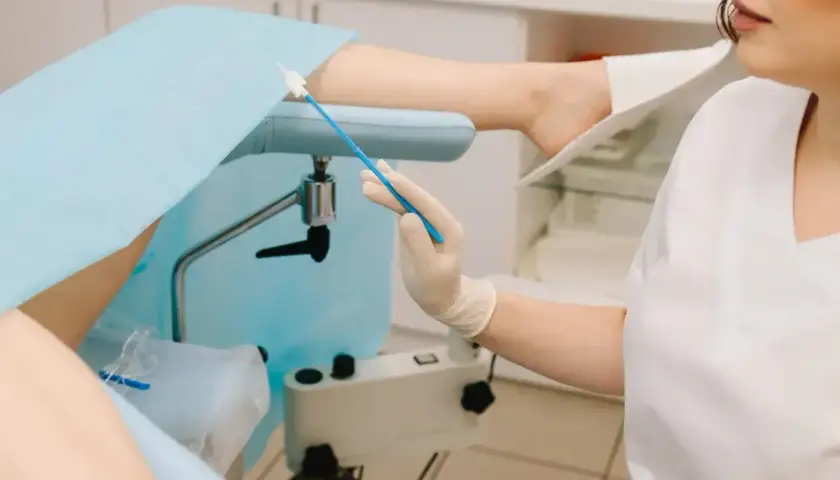 Lekarz przygotowuje się do ginekologicznego badania cytologicznego, pobierając wymaz do analizy.