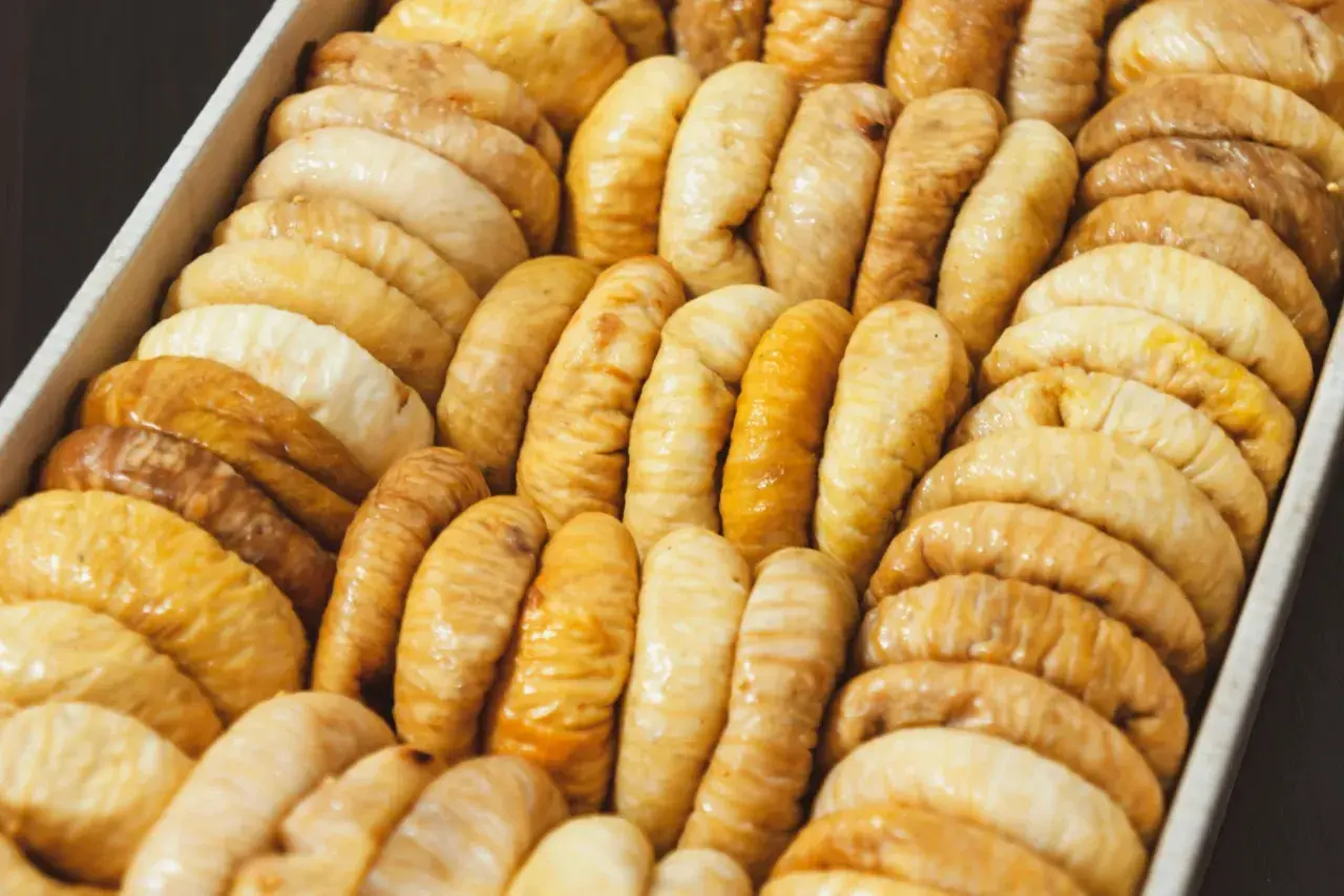 Rządki suszonych fig w pudełku. Te słodkie owoce, bogate w błonnik i minerały, to zdrowa przekąska. Figi suszone właściwości odżywcze.