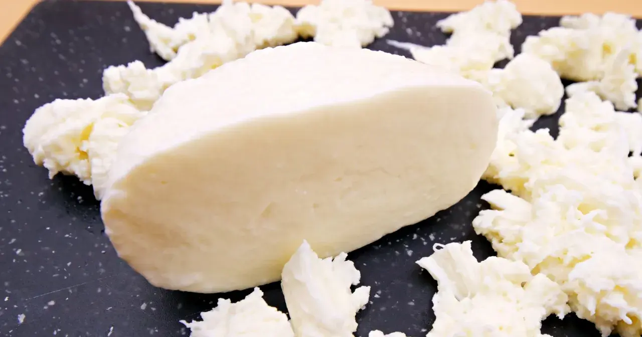 Kawałek świeżej mozzarelli otoczony postrzępionymi kawałkami sera. Idealny do sałatek, a jego mozzarella kcal sprawia, że jest to zdrowy wybór.