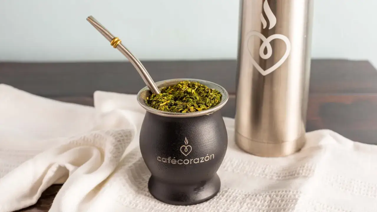 Czarny matero z yerba mate i bombillą. Obok termos z sercem. Odkryj niezwykłe yerba mate właściwości.
