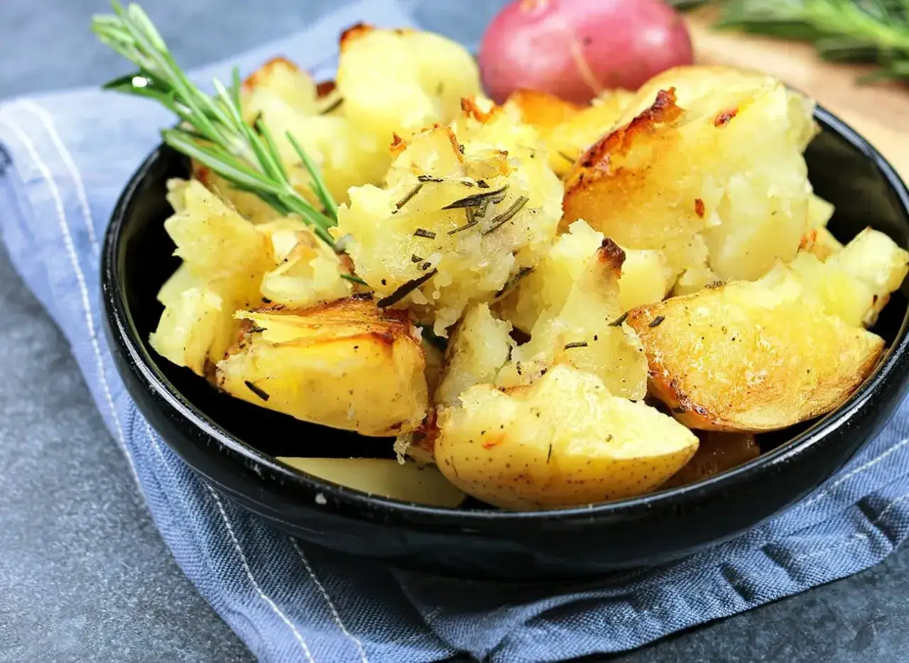 Pieczone ziemniaki z rozmarynem, których właściwości zdrowotne są nieocenione. Aromatyczne zioła podkreślają smak chrupiących ziemniaczków.