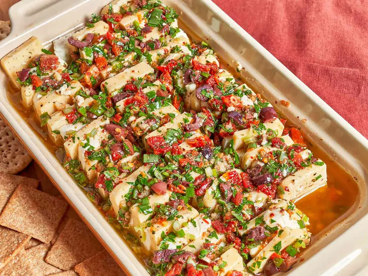 Pyszne pieczone halloumi z pomidorami, oliwkami i ziołami. Idealne do dań z kategorii dieta śródziemnomorska przepisy.